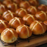 Freshly baked Delicious Hot Cross Buns with perfect icing crosses, ready to enjoy.