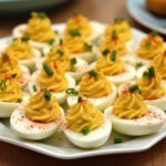 Finished Family Favorite Deviled Eggs garnished with paprika and chives, perfect for sharing.