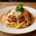 Finished Longhorn Parmesan Chicken with spaghetti and parsley garnish.