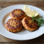Finished salmon cakes garnished with lemon and dill.