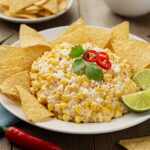Delicious Mexican Street Corn Dip ready to enjoy, perfect with tortilla chips for a delightful Elote Dip experience.