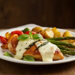 A stunning presentation of Balsamic Baked Chicken Breast with Mozzarella Cheese, garnished with basil and accompanied by roasted vegetables.