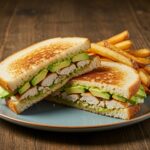 Delicious Chicken Avocado Melt Sandwich displayed with a side of crispy fries, perfect for a satisfying meal.