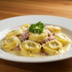 Final plating of creamy tortellini carbonara, showcasing the luxurious texture and appearance, perfect for sharing.