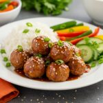 Delicious Teriyaki Chicken Meatballs served with rice and vegetables, featuring a mouthwatering presentation and vibrant colors.
