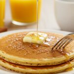 Close-up of a golden vanilla cinnamon buttermilk pancake with melted butter and cinnamon sugar, ideal for a delicious breakfast.