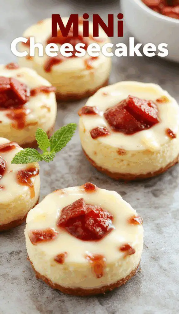 A plate of mini cheesecakes topped with lemon zest and fresh berries, each dessert with a smooth, creamy surface and a golden crust, arranged neatly on a white platter with a rustic wooden background.
