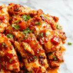 Colorful sheet pan with sizzling chicken strips, vibrant red and green bell peppers, and onions, all caramelized and roasted to perfection, arranged neatly on a baking sheet garnished with fresh cilantro and lime wedges, with a side of soft flour tortillas.